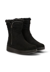 Un par de botas de invierno negras hasta la mitad de la pantorrilla con cremalleras laterales, forro de piel sintética y suelas de goma planas, inclinadas a la derecha sobre un fondo blanco.
