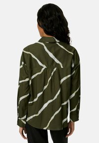 Groen-wit gestreepte overhemdbloes met een rugplooi en lange mouwen, gemaakt van lichtgewicht stof. Voorzien van een klassieke kraag en manchet.