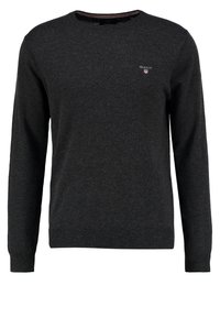 Maglione lavorato a maglia grigio scuro con scollatura a girocollo, maniche lunghe, polsini e orlo a coste, con un piccolo logo sul petto.