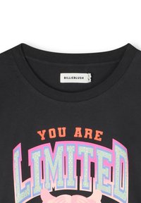 T-shirt nera con scollatura rotonda e la scritta "SEI LIMITATO" in lettere grasse e multicolori con una finitura glitterata e accenti di cartone.