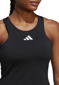 Zwart sportief tanktop met brede bandjes, gemaakt van een gladde stof. Bevat een wit Adidas-logo op de borst. De pasvorm is nauwsluitend.