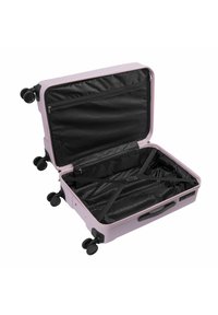 Valigia rigida di un rosa chiaro, con interno nero dotato di tasche in rete con zip e cinghie per fissare il contenuto. Quattro ruote per una facile mobilità.