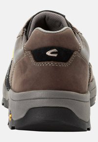 Braune Wildleder-Wanderschuhe mit einer grauen Gummisohle. Sie verfügen über einen gepolsterten Kragen und einen schwarzen Akzent mit einem Logo in der Nähe der Ferse.