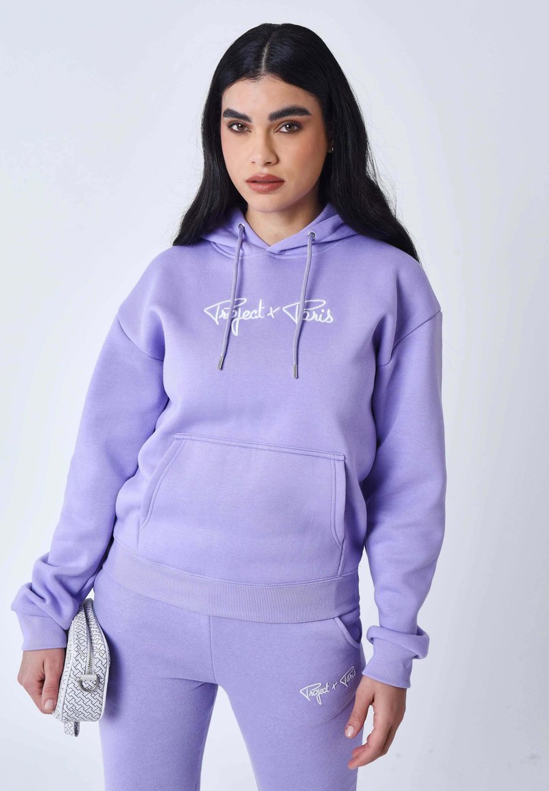 Felpa con cappuccio lavanda e pantaloni abbinati in materiale morbido. Presentano una tasca a marsupio, cappuccio con coulisse e dettaglio logo bianco su entrambi i capi.