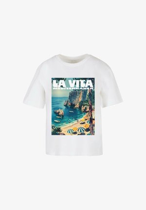 Vit t-shirt i bomull med ett grafiskt tryck av en medelhavstrand med klippor, båtar och färgglada parasoller. Texten lyder "LA VITA MEDITERRANEA."