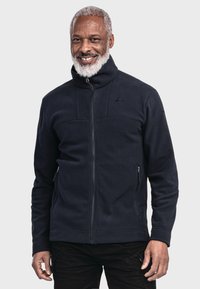Navy-Fleece-Trainingsjacke mit hohem Kragen, ausgestattet mit zwei Seitentaschen und einem dezenten Logo auf der oberen linken Seite. Durchgehend glatte Textur.