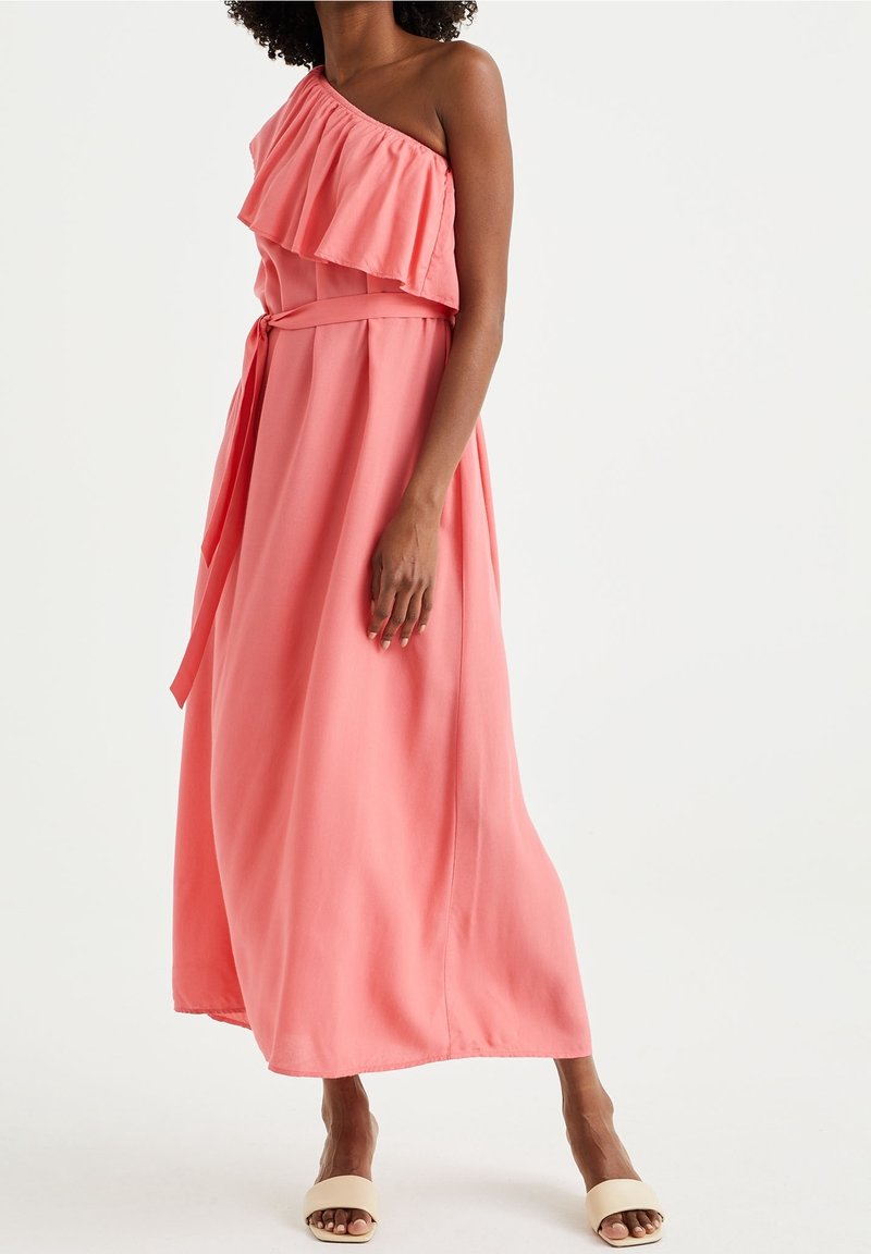 Korálové jednopramenné šaty s volánem na dekoltu, páskem v pase a splývavou midi délkou, vyrobené z lehkého materiálu.