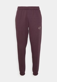 Fialové tepláky z měkké tkaniny, s elastickým pasem, manžetami na koncích a malým logem na boku.