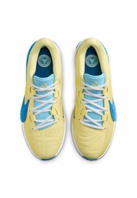 Scarpe sportive gialle e blu con pelle testurizzata, pannelli in mesh, lacci bianchi e un logo circolare sul tallone.