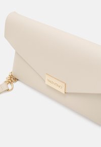Beige obálková kabelka vyrobená z texturovaného materiálu, s zlatým kovovým uzávěrem s vyraženým názvem značky "VALENTINO". Součástí je řetízek.