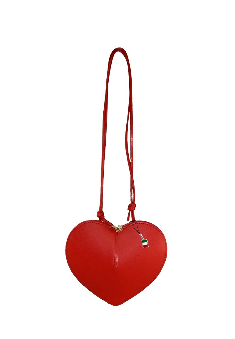 Rode leren tas in de vorm van een hart bevat een ritsluiting, een dunne schouderband en een klein label met een groen, wit en rood ontwerp.