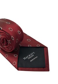 Mörkröd silkesnäcka med ett mönster av små cirklar i vitt och rött. Etiketten visar "HACKETT LONDON" och "MADE IN ITALY" i svart.