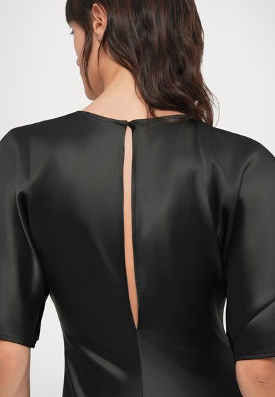 Čierne saténové šaty s výstrihom na chrbte v tvare kľúčovej dierky, krátkymi rukávmi a hladkou textúrou. Dizajn zdôrazňuje elegantnú siluetu.