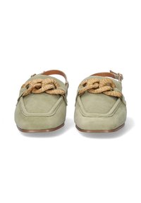 Mules de ante verde con puntera redondeada y un acento de paja anudado. Presentan una correa trasera y una suela plana de color marrón. Textura suave.