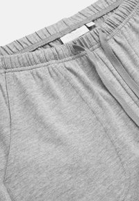 Helle graue Baumwoll-Sweatpants mit einem elastischen Bund, Kordelzug und seitlichen Taschen. Glatte Textur mit feinen Stoffmaserdetails.