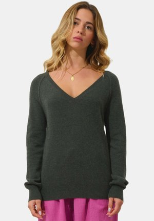 Suéter de punto verde oscuro con diseño de escote en V, mangas largas y puños acanalados. Textura suave y corte relajado.
