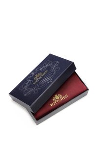 Krabice značky Wittchen s námořnickým exteriérem a složitými stříbrnými vzory, s vínově červenou podšívkou, která vystavuje bohatou, texturovanou stuhu.