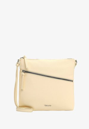 Beige crossbodytas met diagonale ritssluiting aan de voorkant, verstelbare band en zilveren logo-embleem onderaan in het midden.