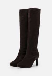Stivali in suede marrone al ginocchio con punta affilata e design elegante, dotati di un sottile tacco a stiletto e dettagli di cucitura minimali.