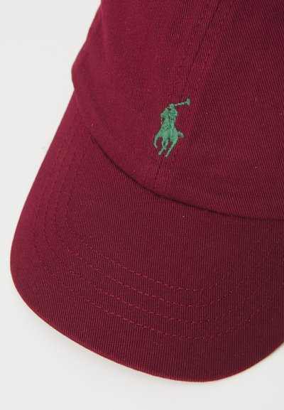 Mørkerød caps med en grøn polo-spillerlogo på forsiden, som viser tekstureret stof og syningsdetaljer.