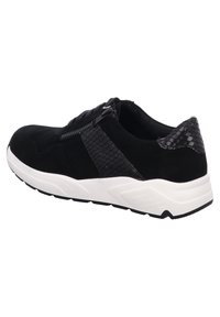 Black suede sneaker with a textured black snake-patterned panel, white midsole, and black rubber outsole. Features lace-up front and zip closure.
