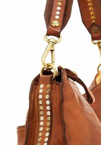 Borsa a tracolla in pelle marrone con borchie metalliche lungo la tracolla, hardware color oro e finitura testurizzata con chiusura con zip.