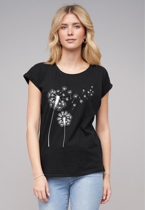 T-shirt noir en coton à manches retroussées, ornée d'un imprimé de pissenlit blanc avec des détails complexes et des tailles variées sur le devant.