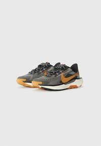 Black and grey athletic shoes with a textured mesh upper, orange accents, and a rubber outsole. Features laces and a cushioned midsole.