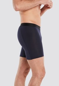 Nachtblaue Boxershorts aus einem glatten, dehnbaren Stoff. Mit einem schwarzen elastischen Bund und einem enganliegenden Design.