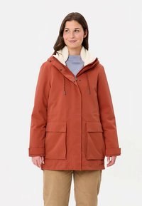 Oranje waterdichte jas met een capuchon gevoerd met fleece, voorzakken, ritssluiting en trekkoorden, ontworpen voor warmte en bescherming.