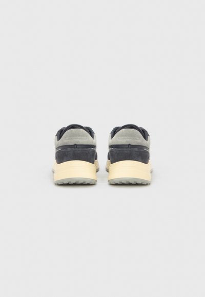 Αθλητικά παπούτσια σε γκρι και ναυτικό μπλε σουέτ με φωτεινή γκρι λαστιχένια σόλα. Διαθέτουν επενδεδυμένο γιακά και υφασμάτινο σχέδιο στο άνω μέρος.