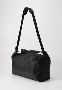 Black duffel bag with a rectangular shape, made from durable fabric. Features a detachable strap and dual handles for versatile carrying options.