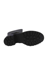 Suola di stivale in gomma nera con motivo testurizzato caratterizzato da forme esagonali, tacche profonde per presa e design della punta liscia e arrotondata.