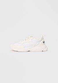 White low-top sneaker with mixed mesh and leather upper, lace-up closure, chunky sole, and black "HUGO" text on heel tab.