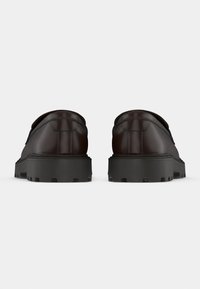 Καφέ δερμάτινα παπούτσια με χαμηλή κοπή, χοντρές μαύρες λάστιχες σόλες και ραφές στο πίσω μέρος. Διαθέτουν λείο υλικό και μινιμαλιστικό σχέδιο.