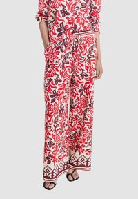 Brede broek met bloemmotief in rood, wit en bruin, met een trekkoord in de taille en zijzakken.