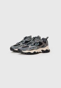 Scarpe da ginnastica nere e grigie con tessuto testurizzato, dettagli in rete, rifiniture riflettenti e una suola grossa con intersuola beige maculata.
