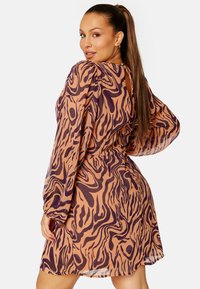 Korte mouwen jurk in een transparante, lichte stof met een bruin en paarse zebra print, met een geraffineerde taille en een open rug ontwerp.