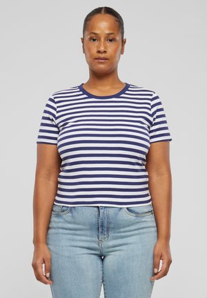 Maglietta a righe con maniche corte, caratterizzata da strisce orizzontali bianche e blu scuro. Collo rotondo e design aderente. Indossata con jeans azzurri.