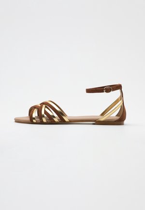 Ruskeat samettiset sandaalit, joissa on kultaiset metalliset hihnat, avonainen kärki ja nilkkahihna metallisoljella. Littele pohja, vähäiset yksityiskohdat, rento tyyli.