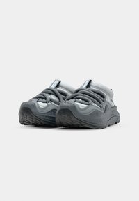 Szare sneakersy z teksturowaną cholewką, okrągłym noskiem, elastycznymi sznurówkami oraz gumową podeszwą. Posiadają wyściełane kołnierze i minimalistyczny design.