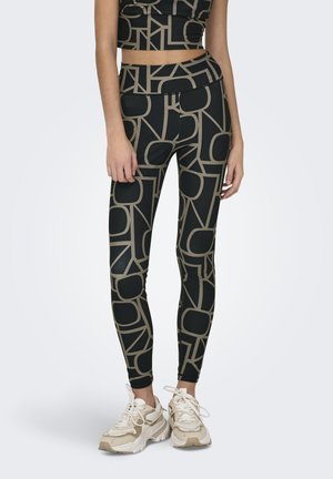 Zwarte leggings met een geometrisch beige patroon, hoog in de taille, gemaakt van rekbaar materiaal, gecombineerd met chunky sneakers in neutrale tinten.