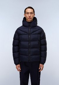 Marineblå pufferjakke med høj krave og lynlås, der har vandrette quiltede paneler og elastiske manchetter for bedre pasform. Casual design.