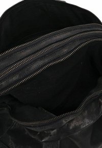 Borsa in pelle nera con due scomparti con zip, texture liscia e interno foderato, che presenta una forma morbida e strutturata.