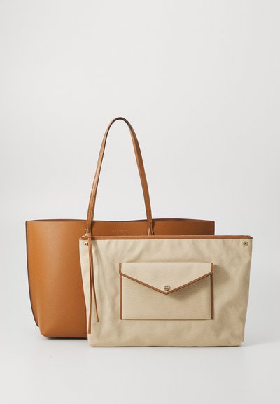 Sac fourre-tout en cuir brun avec deux poignées à côté d'un sac en toile beige comportant une poche à rabat à l'avant et des accents en cuir marron.