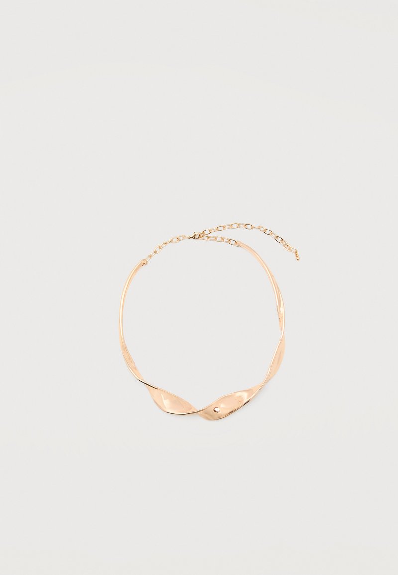 Χρυσό κολιέ τσόκερ από στριφογυριστό μέταλλο με ρυθμιζόμενο κούμπωμα αλυσίδας σε απλό ανοιχτό φόντο.