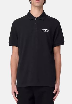 Camisa polo negra de algodón, con el logo de la marca "VERSACE JEANS COUTURE" en el lado izquierdo del pecho, mangas cortas y un cuello clásico.