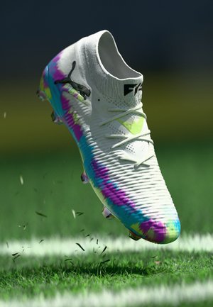 Weißer Fußballschuh mit strukturiertem Obermaterial, das ein farbenfrohes Farbverlaufsmuster in Pink, Blau und Grün zeigt. Schwarzes Logo an der Seite.