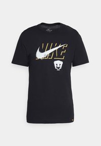 T-shirt en coton noir à manches courtes avec un logo Nike blanc et un motif de lion en jaune, impression texturée à l'avant.