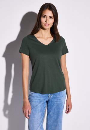 Mørkegrøn V-hals t-shirt lavet af blødt stof, korte ærmer, afslappet pasform, parret med lyseblå vide ben jeans. Minimalistisk design, ingen mønstre.